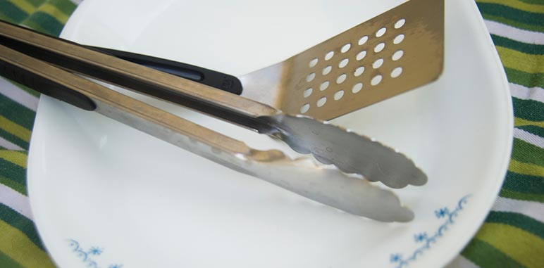 cooking tongs and spatula on a platter
