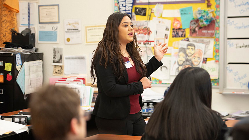 A woman stands at the front of a classroom