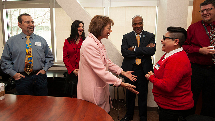 Susan Heredia reaches out to greet Ana Garcia as others look on