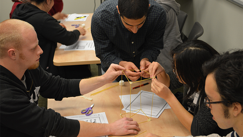 Students work with spaghetti and marshmallows for a team-building exercise