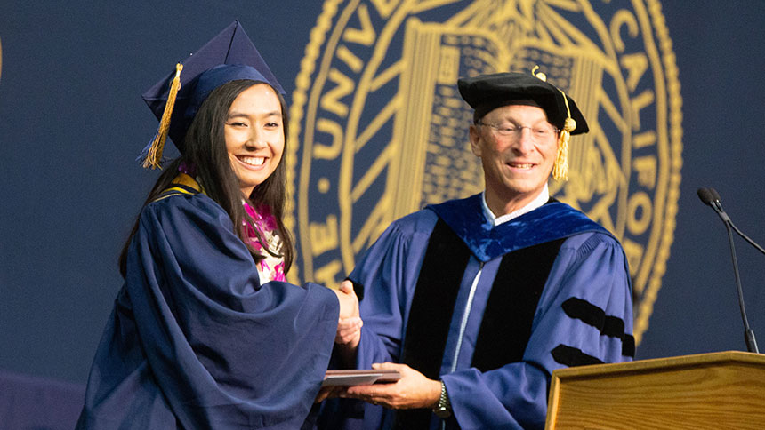 Ralph Hexter, provost and executive vice chancellor, presents an award to Emily Eijansantos at commencement