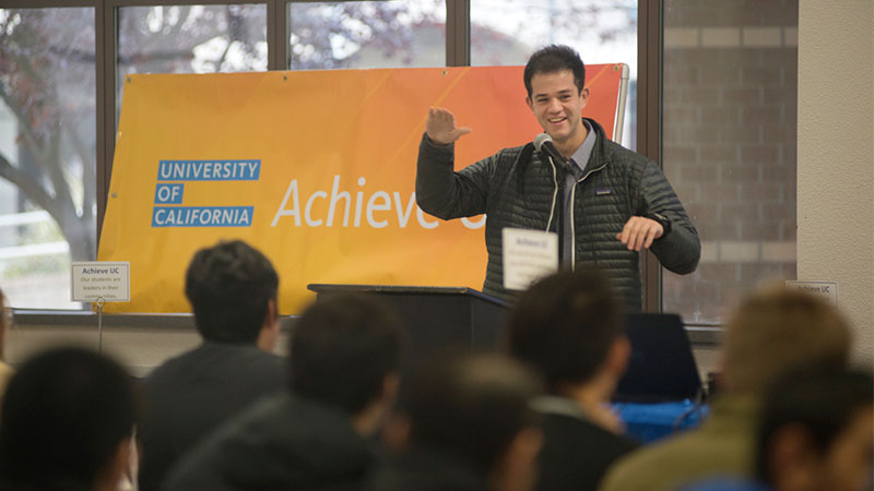 A man speaks to seated students