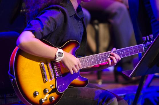 A student playing a guitar.