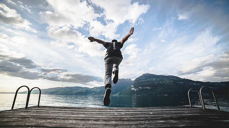 A student jumping off dock at a lake near Florence, Italy