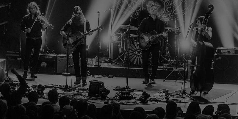 Black and white photo of members of the band performing on stage.